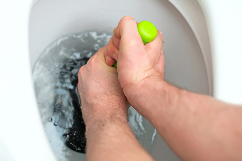 Person using a plunger on a toilet Renton, WA Person using a plunger on a toilet Renton, WA